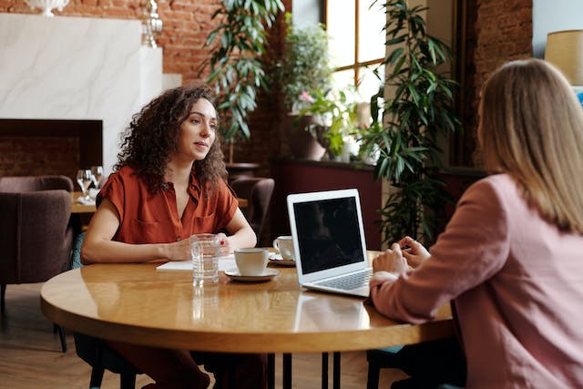 Two people sitting at a table in a coffee shop.