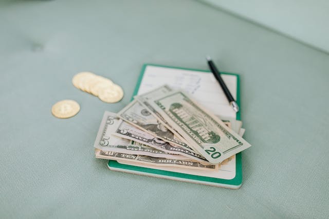 A clipboard with some American money on top of it.